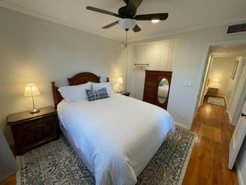 埃尔森特罗The Corner Cottage的卧室配有白色的床和吊扇