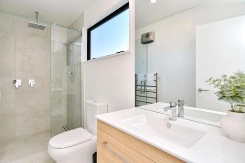 基督城Chatham Street - Christchurch Holiday Homes的一间带水槽和卫生间的浴室以及窗户。