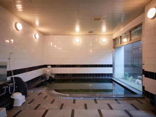 笛吹市Tabist Onsen Hotel Toyo的游泳池,浴室设有卫生间