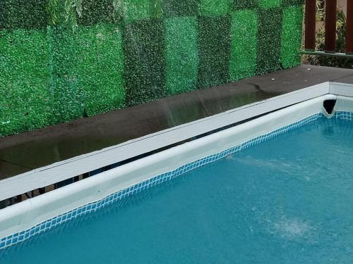 Kampong PekA&P Inn Homestay的一座带绿色墙壁和水的游泳池