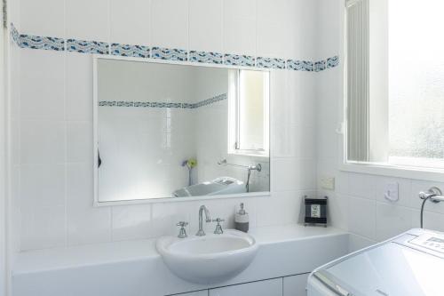 贝拉拉Coral Cottage的白色的浴室设有水槽和镜子