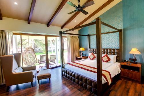钦奈MGM Beach Resorts East Coast Road的一间卧室配有一张床、一把椅子和窗户。