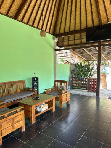蓝梦岛Island Garden Huts Lembongan的客厅配有木制家具和绿色墙壁