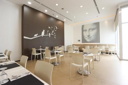 马尼拉Privato Ortigas的一间带桌椅和大墙的餐厅