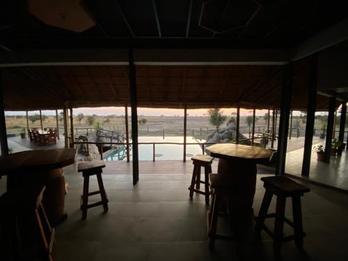 MababeMababe River Campsite的餐厅设有凳子,享有游泳池的景色