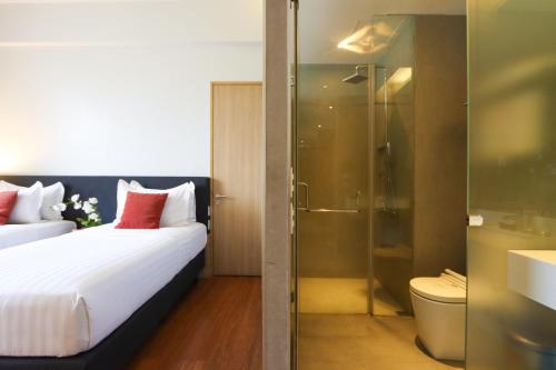 马尼拉Privato Quezon City的酒店客房配有一张床和淋浴