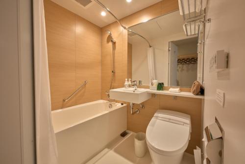 金泽金泽 穎特飯店的浴室配有卫生间、盥洗盆和浴缸。