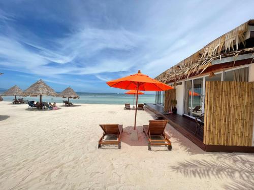 西塔努尼斯海度假村的沙滩上设有两把椅子和一把遮阳伞