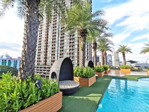 曼谷Capital O 75451 Podstel Hostel Bangkok的一座棕榈树酒店游泳池和一座建筑