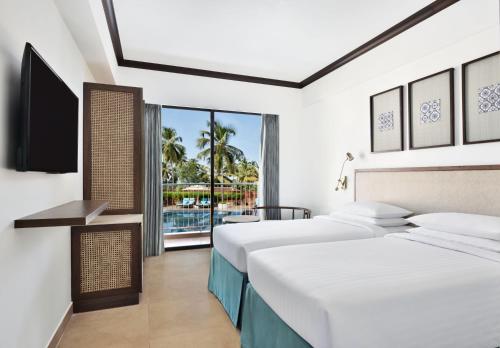 安君纳Fairfield by Marriott Goa Anjuna的酒店客房设有两张床和电视。
