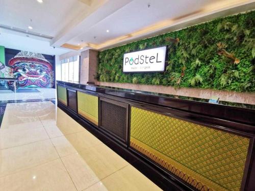 曼谷Capital O 75451 Podstel Hostel Bangkok的带有绿色墙壁的餐厅的大堂
