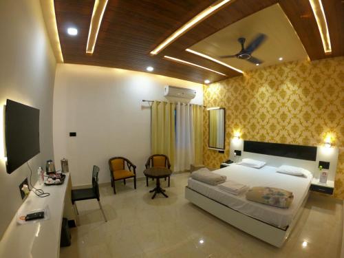 瓦拉纳西Hotel Buddha Park near Sarnath, Varanasi的卧室配有一张床和一张桌子及椅子