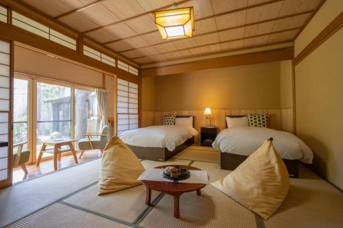 山之内町嘉美浴场旅馆的一间卧室配有两张床和一张桌子。