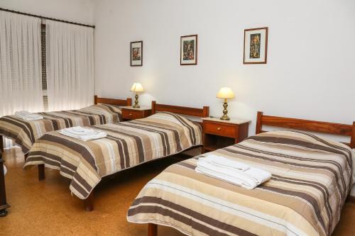 圣玛尔塔迪佩纳吉昂Hotel Oasis的酒店客房的三张床,配有毛巾