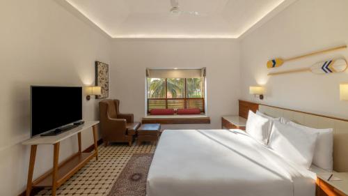 卡乌罗西姆果阿多纳西尔维亚诺富特度假村的酒店客房设有一张大床和一台电视。