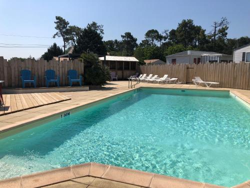 圣让-德蒙Camping Le Logis 3 étoiles的一个带蓝色椅子和围栏的游泳池