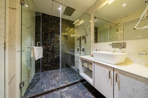 ĀsansolPayel Inn的一间带玻璃淋浴和水槽的浴室
