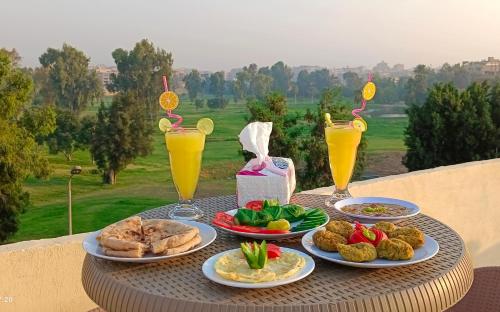 开罗Crystal pyramid inn的餐桌,带食物盘和橙汁杯