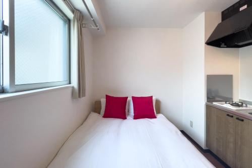 东京Elegant House的一间卧室配有一张带两个粉红色枕头的床
