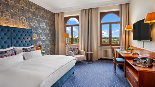 德累斯顿德累斯顿拜耳斯彻酒店的配有一张床和一张书桌的酒店客房