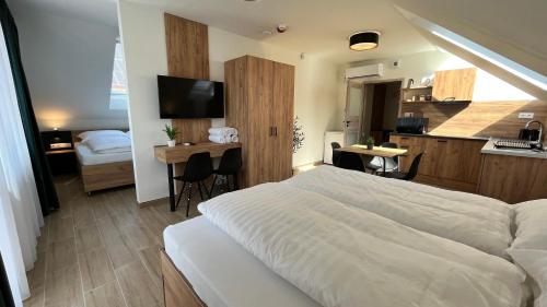 塞格德Rezidex Apartmanház的一间带一张床和一张书桌的卧室和一间厨房
