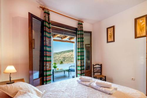 卡皮雷拉Casa Jose Capileira - Alpujarra的一间卧室设有一张床,享有阳台的景色