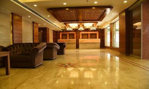 钦奈FabHotel Prime The Vijay Park的大型大堂设有沙发和桌子,地面层