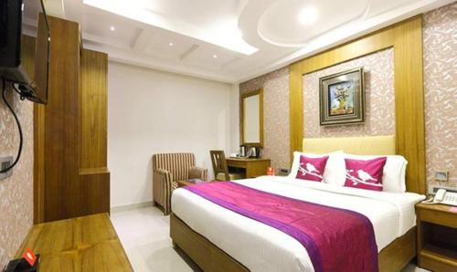钦奈FabHotel Prime The Vijay Park的酒店客房设有一张大床和一张书桌。