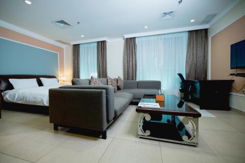 科威特拉古娜套房公寓的客厅配有沙发和1张床