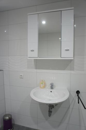 维勒斯威特2- Zimmer-Wohnung的白色瓷砖浴室内的白色水槽