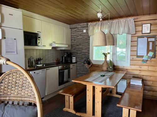 罗瓦涅米Vikajärvi Lake View Experience Igloos的厨房配有木桌和冰箱。