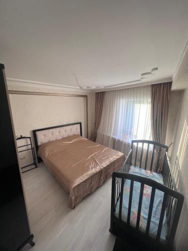 乌拉尔斯克Уютная 3 комнатная квартира的卧室配有床、椅子和窗户。