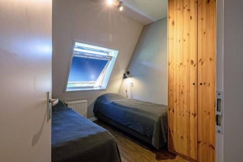 德科赫Heerlijk appartement op Texel vlakbij bos en zee.的一间小卧室,配有床和窗户
