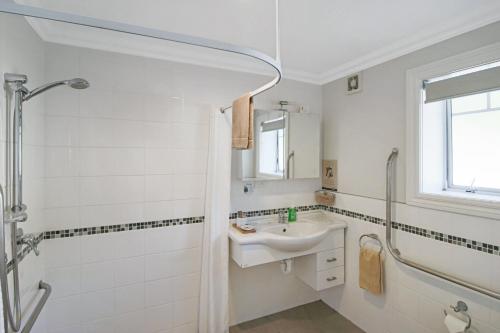 凯里凯里凯里凯里公园汽车旅馆的白色的浴室设有水槽和淋浴。