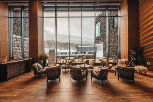 赤井川Yu Kiroro, Ski-in Ski-out Luxury Residences的大堂设有桌椅和大窗户。