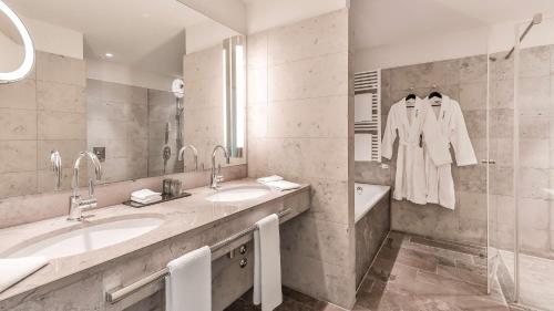科隆科隆干草市场多林特酒店的浴室设有2个水槽、镜子和浴缸。