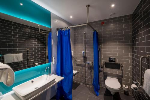 卢塞恩Holiday Inn Express - Luzern - Kriens, an IHG Hotel的浴室配有蓝色的浴帘和卫生间
