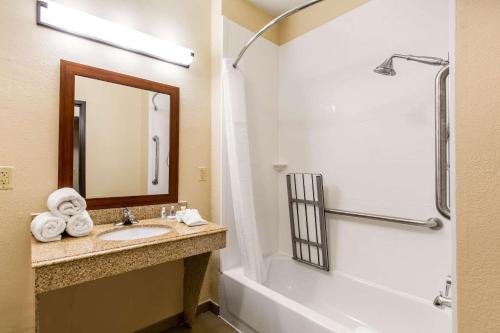 亨博尔东部IAH布什机场舒适套房酒店的一间带水槽、浴缸和镜子的浴室