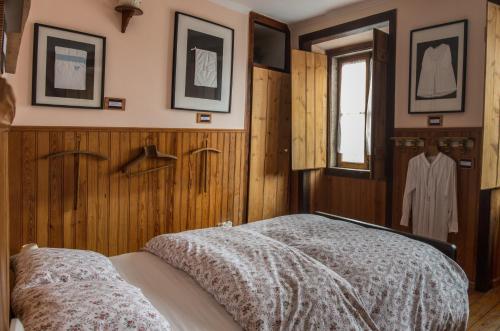 辛特拉辛特拉小型旅馆的一间卧室设有木墙和一张带毯子的床