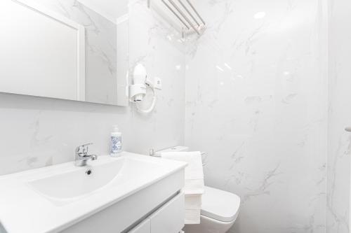 里斯本Príncipe Apartamentos e Suites的白色的浴室设有水槽和卫生间。