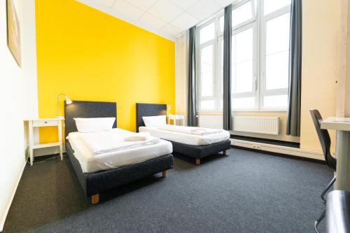 柏林Industriepalast Berlin的一间设有两张床和黄色墙壁的客房