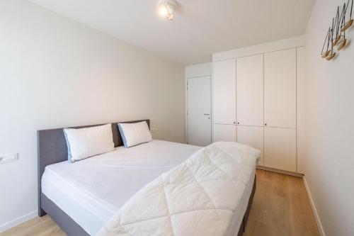 尼乌波特VivaVela的卧室配有一张白色大床和白色橱柜。