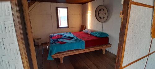 EkasEkas beach floating room and restaurant的小房间的小卧室配有床