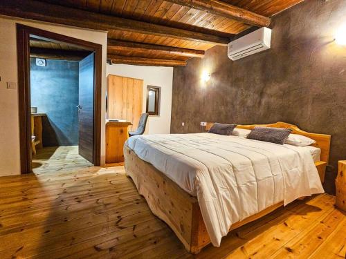 StérnaiCisternis Villa的一间卧室设有一张大床,铺有木地板