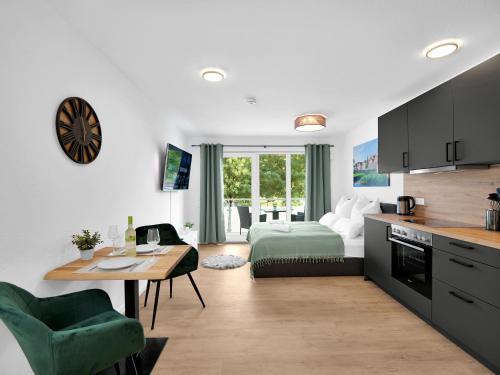 施韦比施哈尔INhome Studio Apartment - Küche - Parken - TV的厨房以及带床和桌子的客厅。