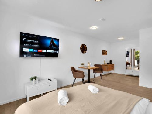 施韦比施哈尔INhome Studio Apartment - Küche - Parken - TV的一间卧室设有两张床,墙上配有电视。