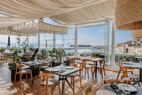 伊西翁LAS HOTEL & SPA的餐厅设有桌椅和大窗户。