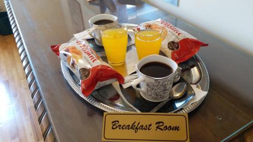 布加勒斯特Bucharest Boutique Accommodation by Hotels的托盘,上面放有两杯橙汁和一盘早餐盘