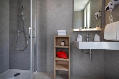 塞纳河畔讷伊查理曼酒店的带淋浴、盥洗盆和淋浴的浴室
