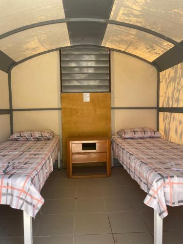 费拉Santorini Camping & Hostel的一间设有两张床和一张桌子的房间